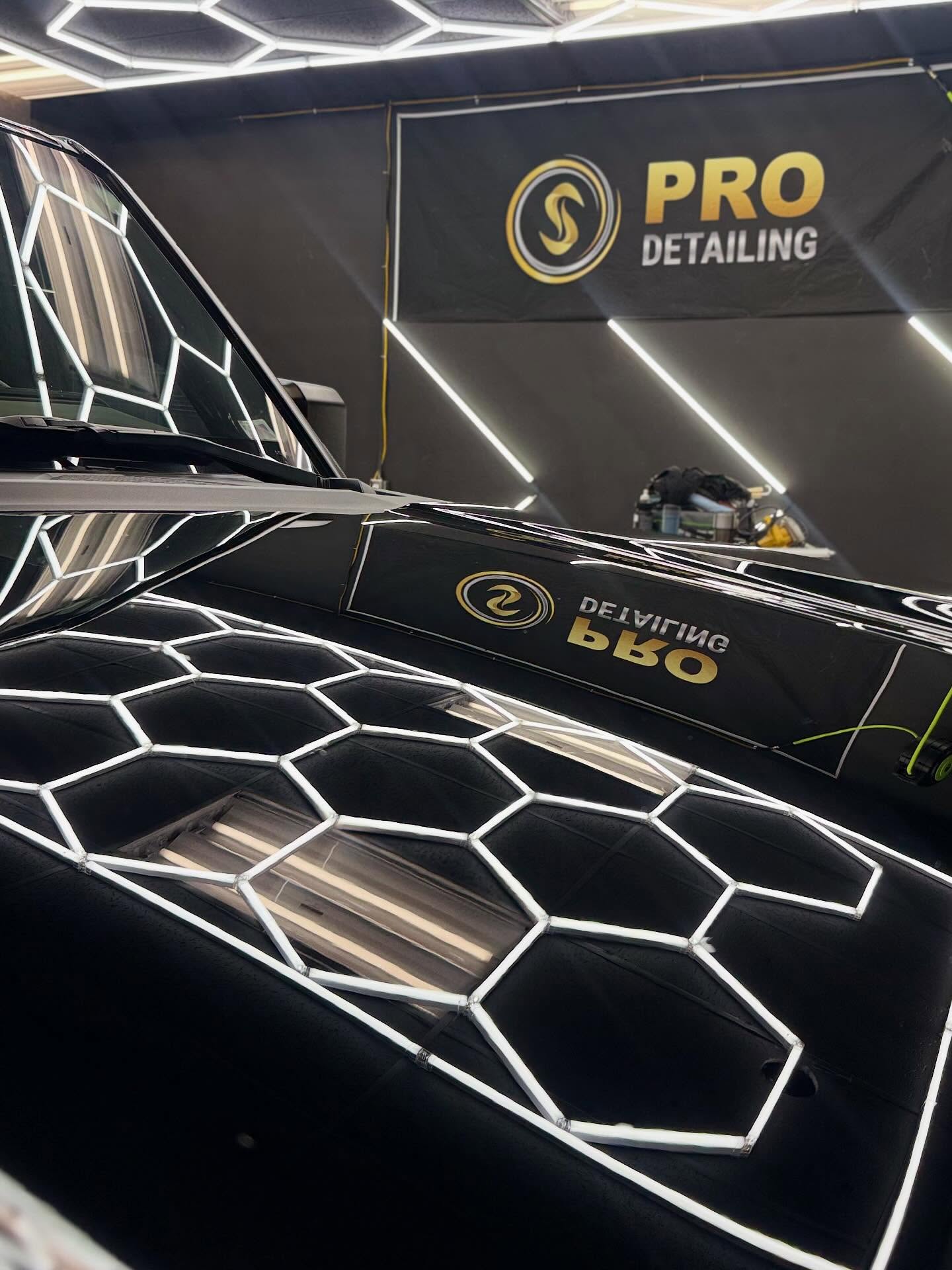 Swirl-free paint finish check under hexagon LED lighting after PPF installation at OS Pro Auto Detailing in Mercer Island, WA