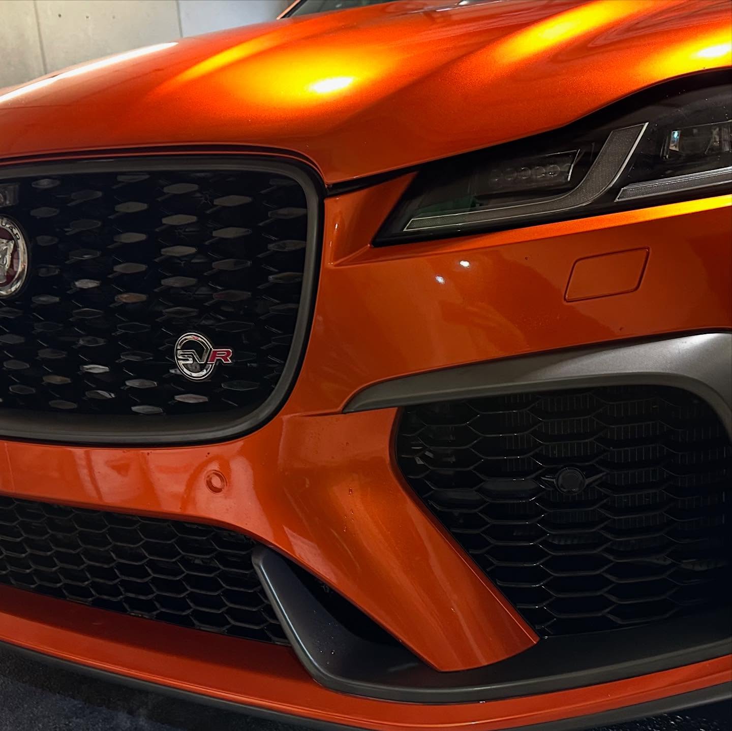 Glossy paint protection film finish on an orange Jaguar F-TYPE SVR hood and grille — OS Pro Auto Detailing PPF service in Kirkland, WA